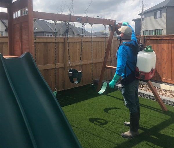 Buzz Boss technician spraying a playground against pests