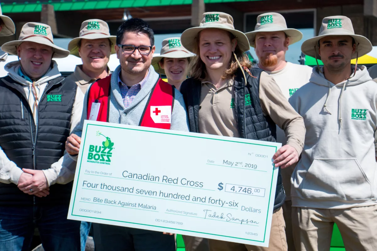 Buzz Boss employees with a Red Cross activist holding a cheque
